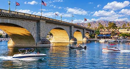 Historic London Bridge over Bridgewater Channel with pleasure boats and desert mountains at Lake Havasu Arizona