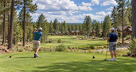 Two golfers on a Show Low Arizona golf course surrounded by ponderosa pine forests and mountain cabins