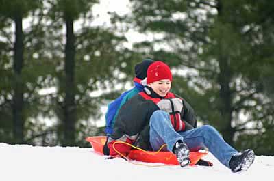 kids sledding in the snow